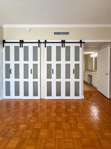 a view of room with walk in closet and wooden floor