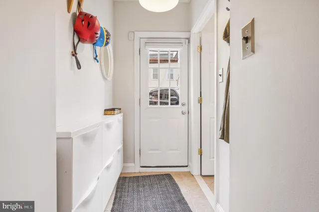 a view of a hallway with white cabinet and door