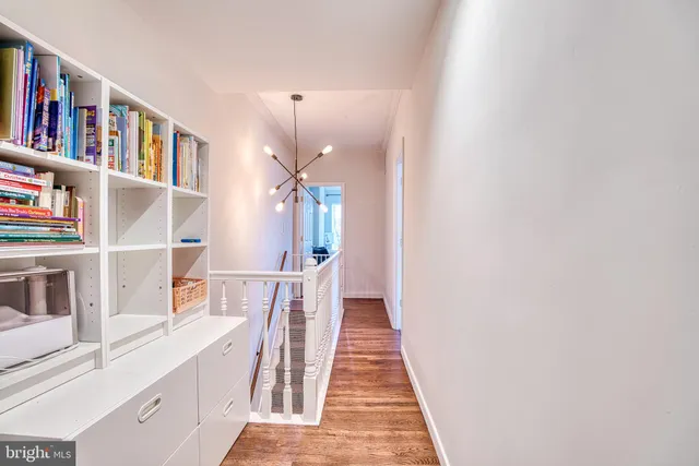 a hallway with cabinets and a book shelf
