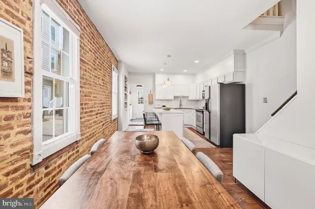 a kitchen with stainless steel appliances kitchen island granite countertop a refrigerator and a sink