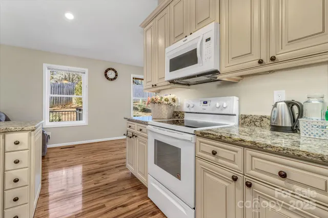 a kitchen with stainless steel appliances granite countertop a sink and a stove