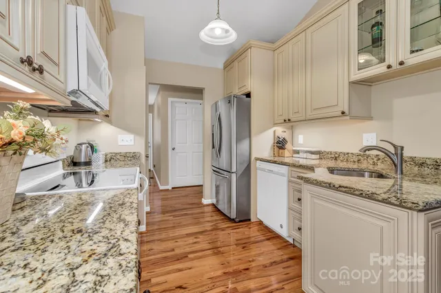a kitchen with stainless steel appliances granite countertop a sink stove and refrigerator