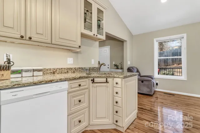 a kitchen with granite countertop white cabinets and white appliances