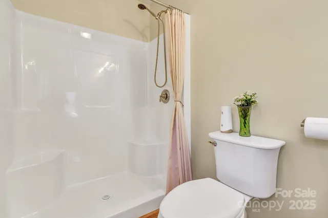 a white toilet sitting next to a bath tub