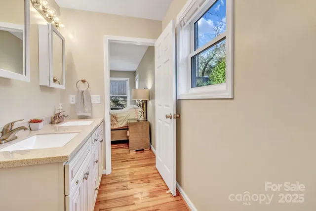 a bathroom with a double vanity sink a mirror and a bathtub