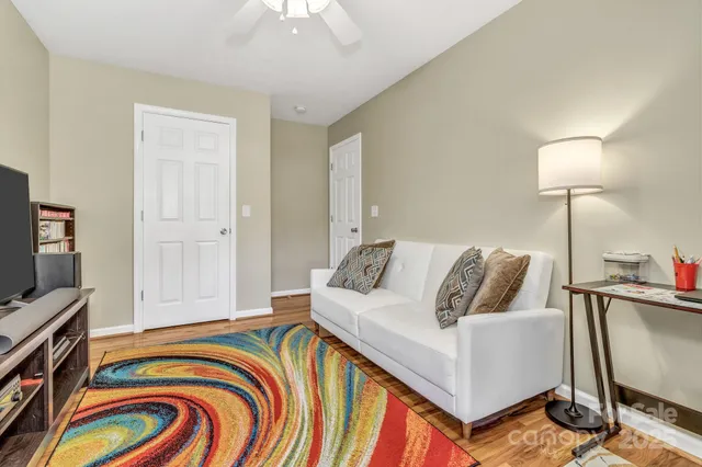 a living room with a bed and a flat screen tv
