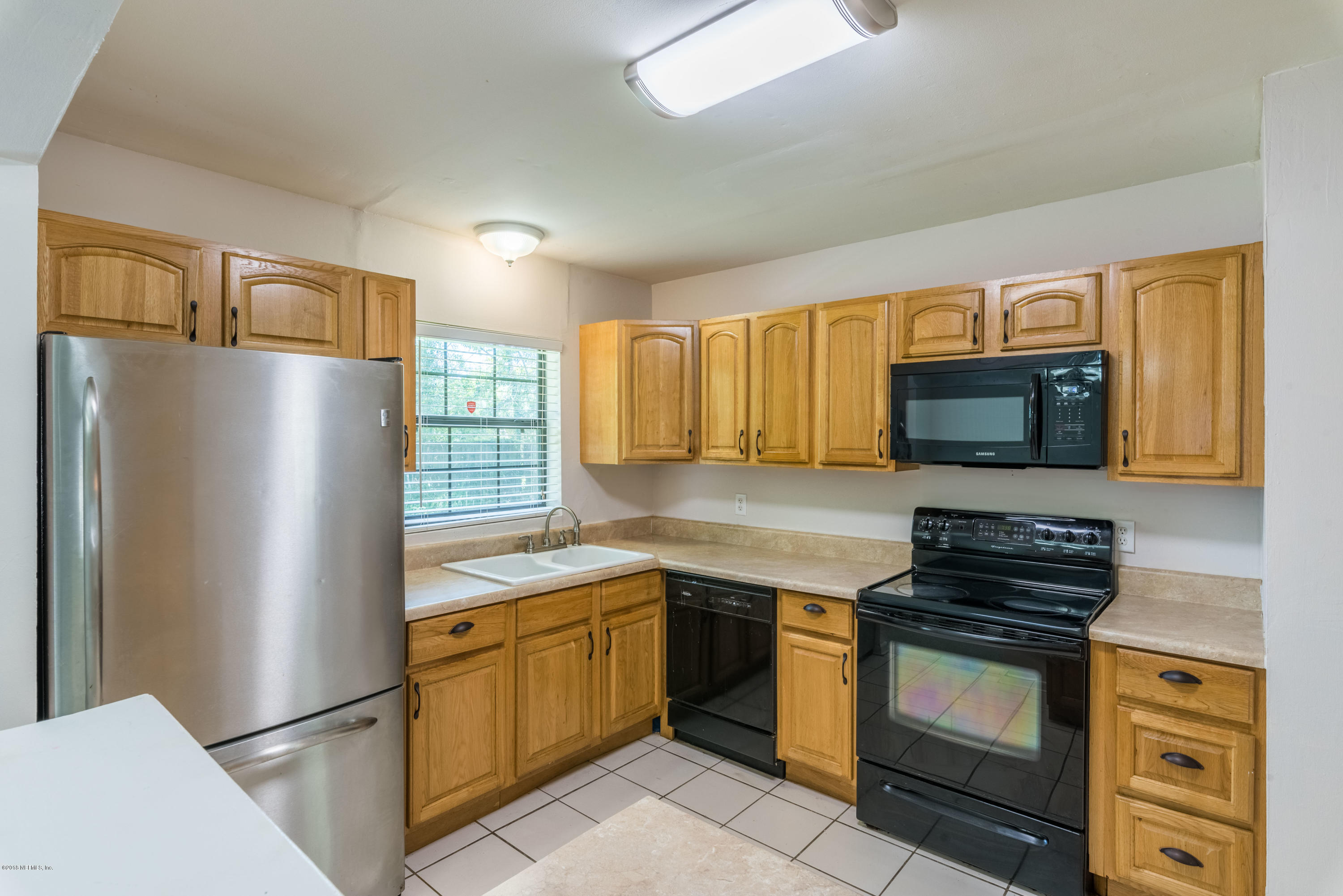 7477 Strato Road Jacksonville, FL 32210 - Photo 11 of 25 a kitchen with a refrigerator stove and sink