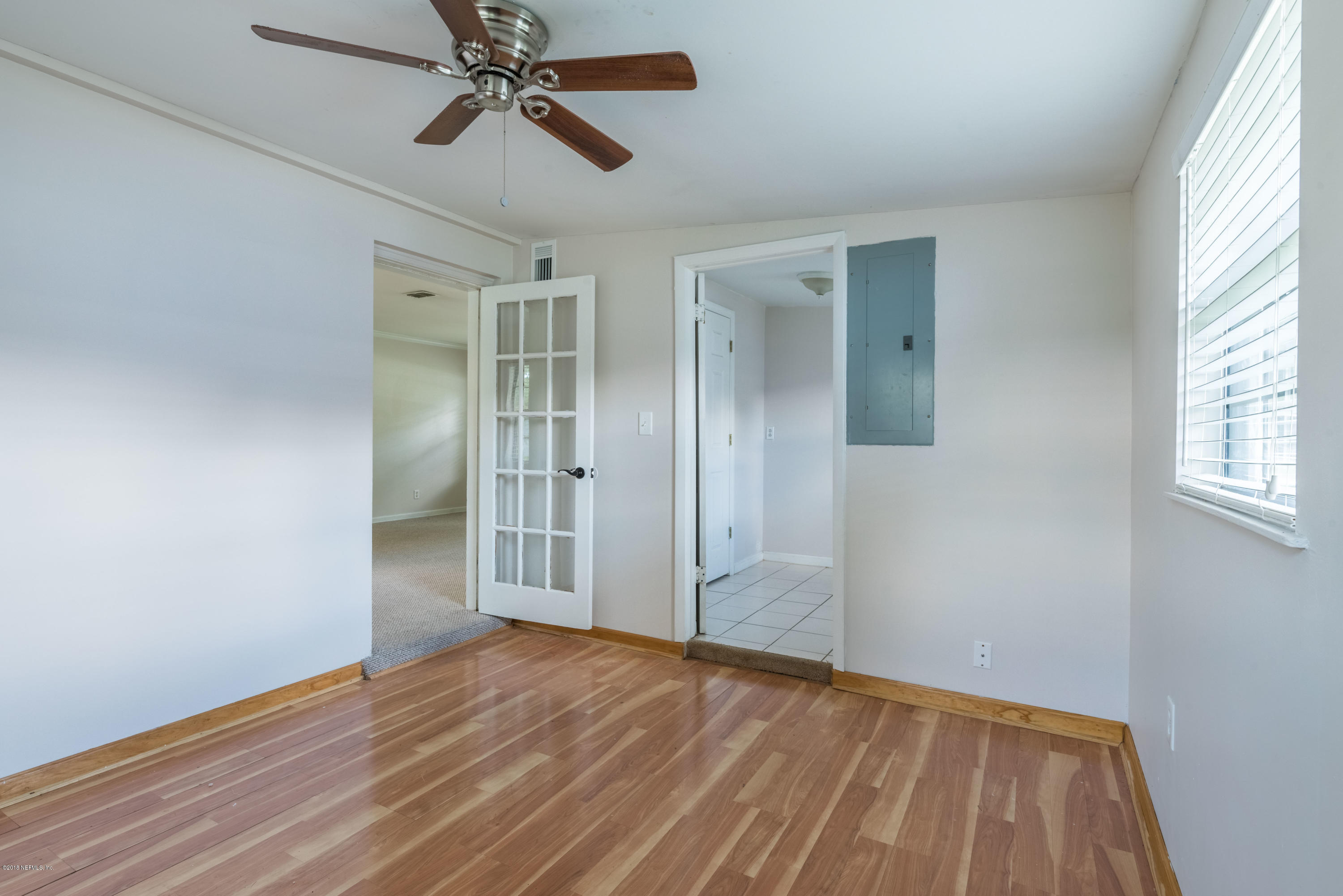 7477 Strato Road Jacksonville, FL 32210 - Photo 14 of 25 wooden floor in an empty room with a window