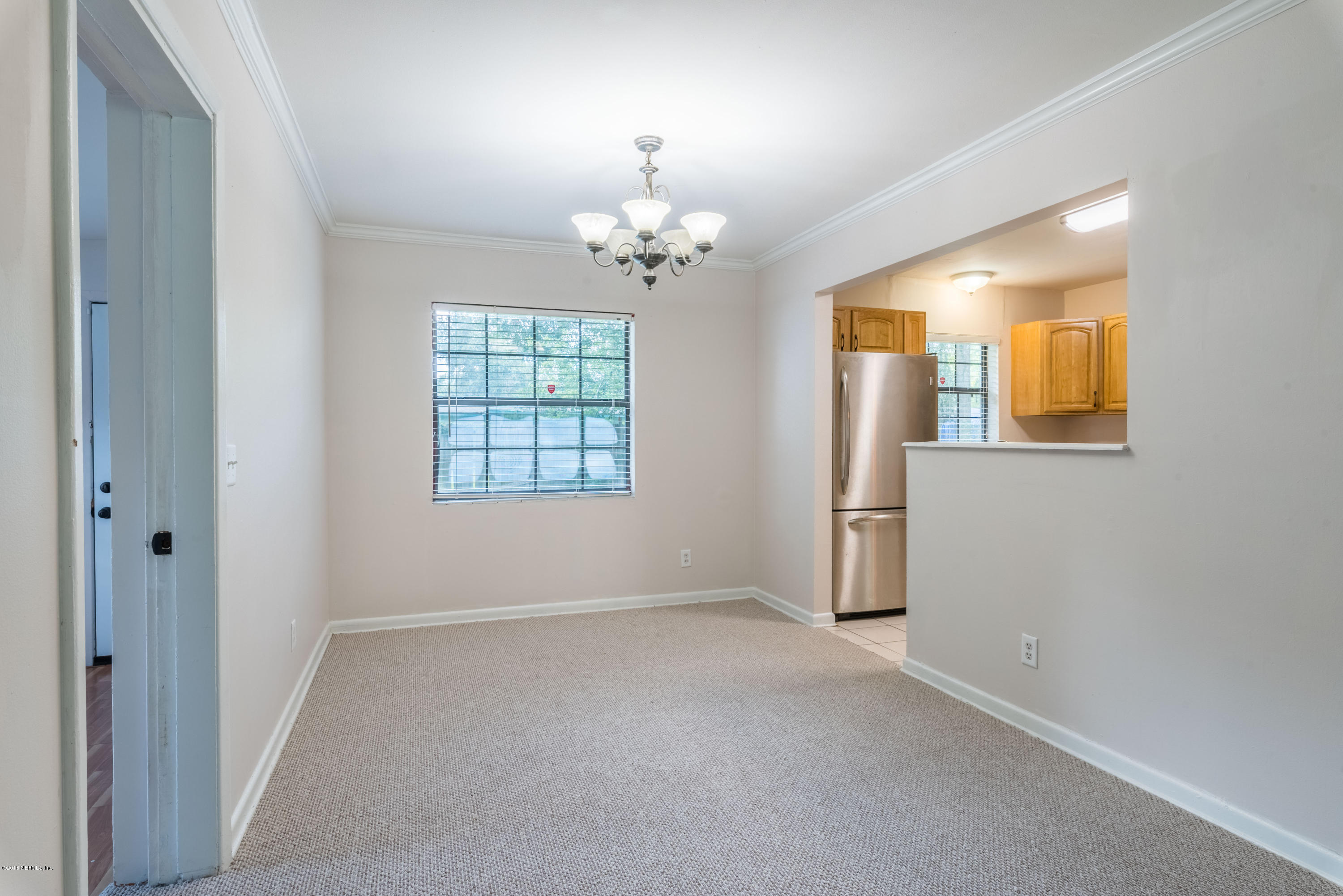 7477 Strato Road Jacksonville, FL 32210 - Photo 8 of 25 wooden floor in an empty room with a window