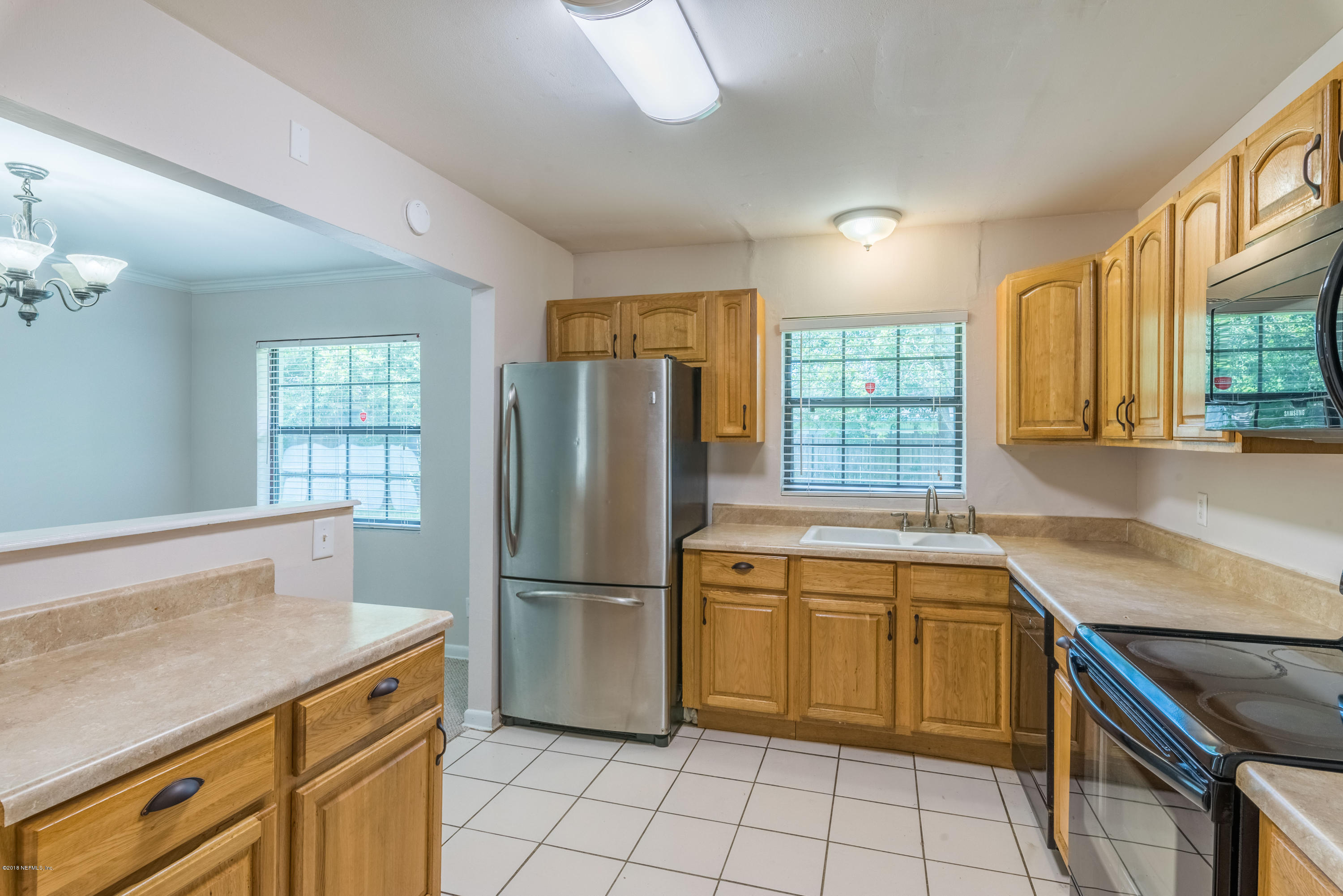 7477 Strato Road Jacksonville, FL 32210 - Photo 10 of 25 a kitchen with a stove a sink and a refrigerator
