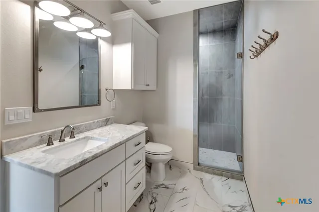 a bathroom with a sink and mirror with toilet