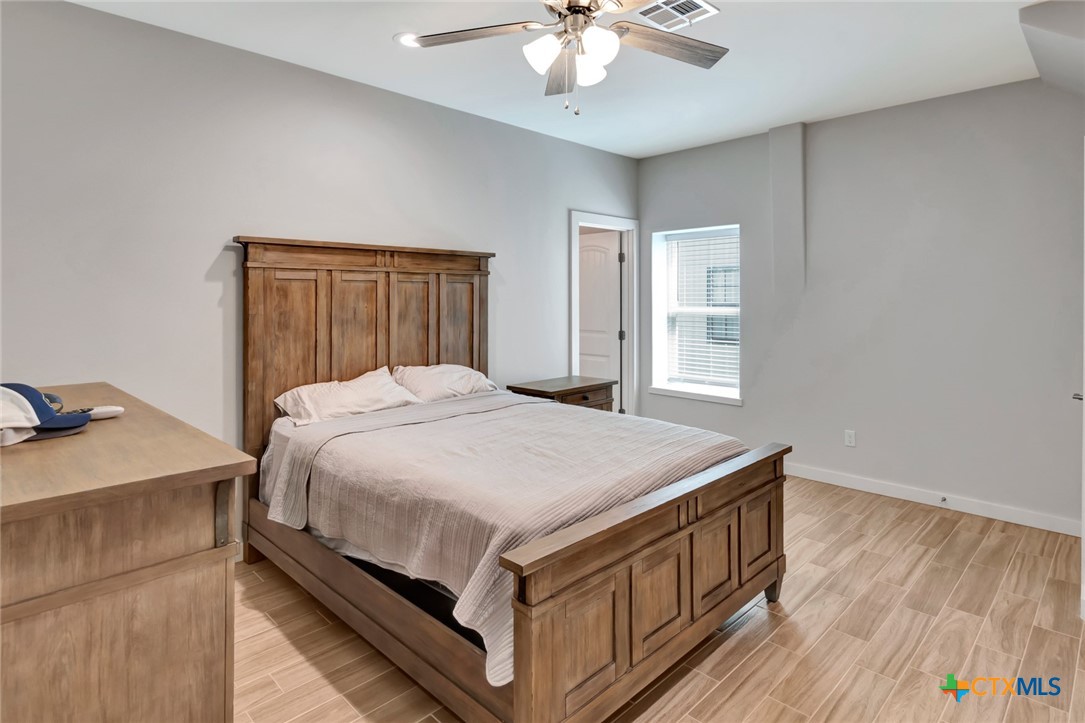 52 Coastal Oaks Loop Port O'Connor, TX 77982 - Photo 12 of 23 a bedroom with a bed and a chandelier