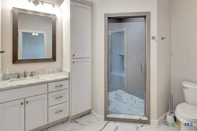 a bathroom with a granite countertop toilet sink and shower