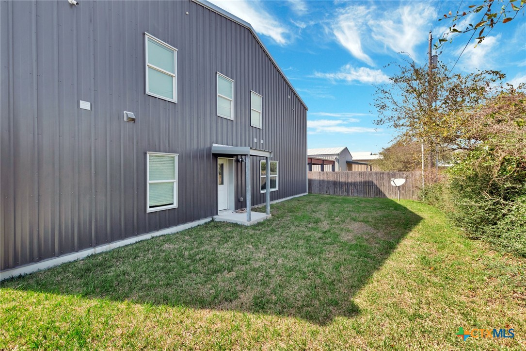 52 Coastal Oaks Loop Port O'Connor, TX 77982 - Photo 23 of 23 a view of a house with brick walls and a yard with plants