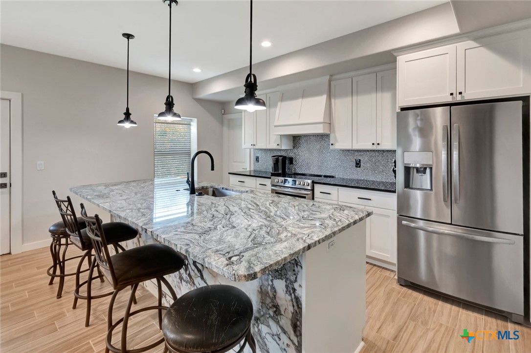52 Coastal Oaks Loop Port O'Connor, TX 77982 - Photo 6 of 23 a kitchen with stainless steel appliances granite countertop a sink a microwave a refrigerator and a stove