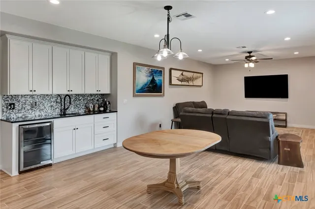 a kitchen with stainless steel appliances a stove a sink a microwave a dining table and chairs