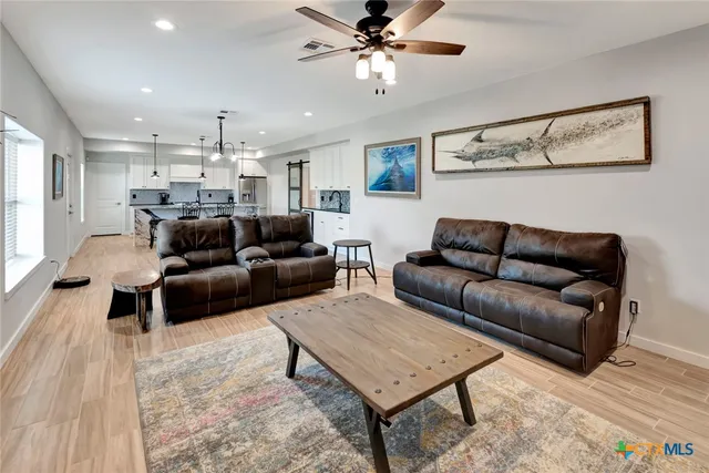 a living room with furniture and a chandelier