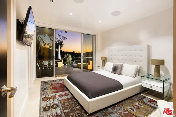 a large bedroom with bed and wooden floor