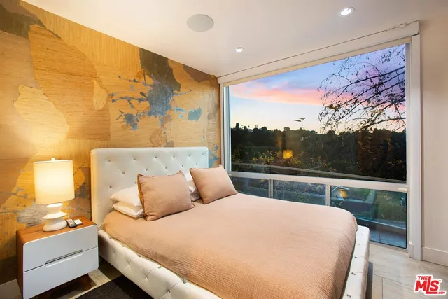 a bedroom with a large bed and a balcony view