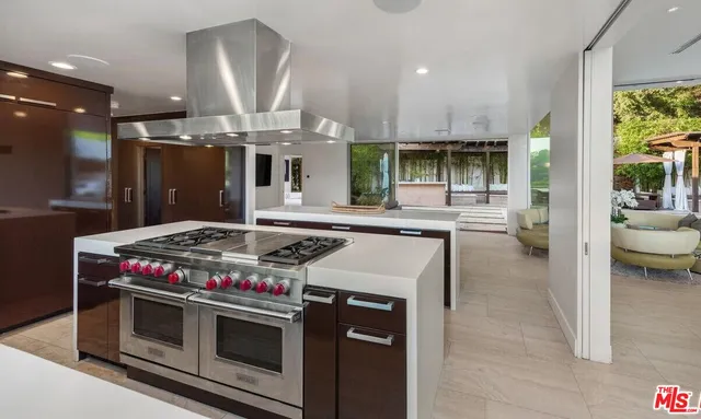 a kitchen with a stove and a view of living room