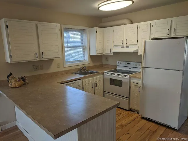 a kitchen with cabinets appliances a sink and a counter space