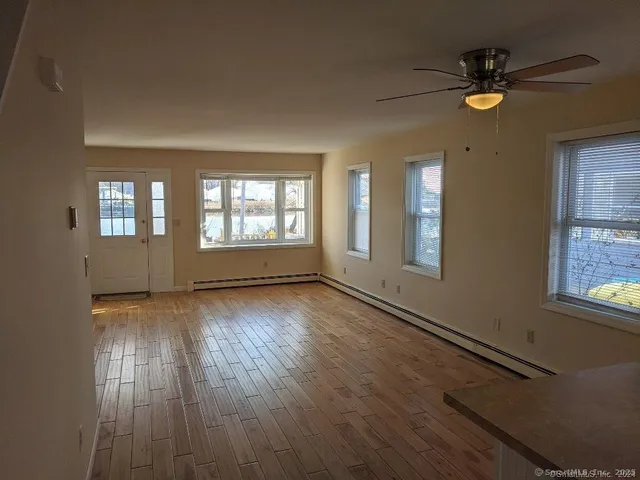an empty room with wooden floor and windows