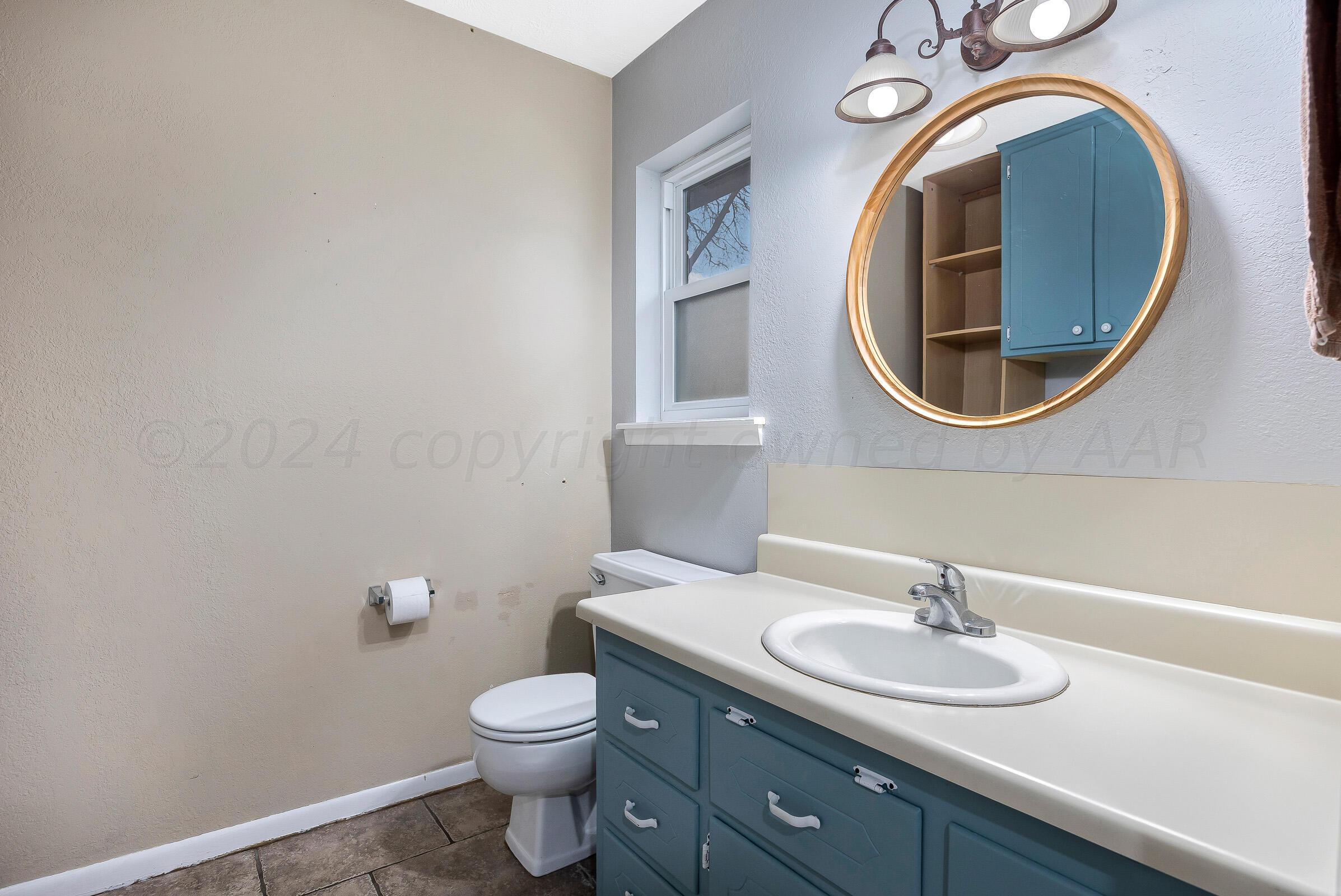 6903 Dreyfuss Road Amarillo, TX 79106 - Photo 25 of 27 a bathroom with a toilet sink and mirror