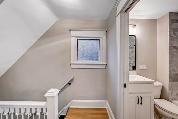 a view of an empty room with wooden floor and closet