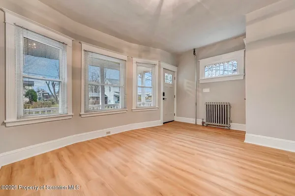 a view of a room with wooden floor and entryway