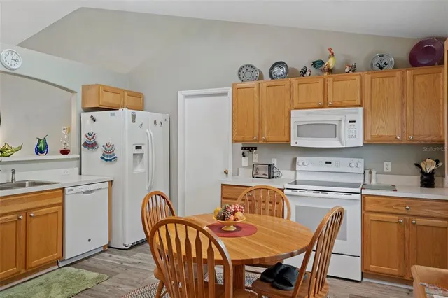 a kitchen with stainless steel appliances granite countertop a dining table and chairs