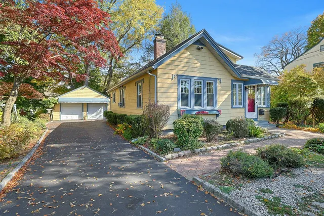 a front view of a house with a yard and trees