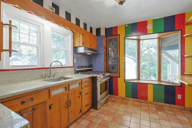 a kitchen with stainless steel appliances granite countertop a stove a sink and a microwave