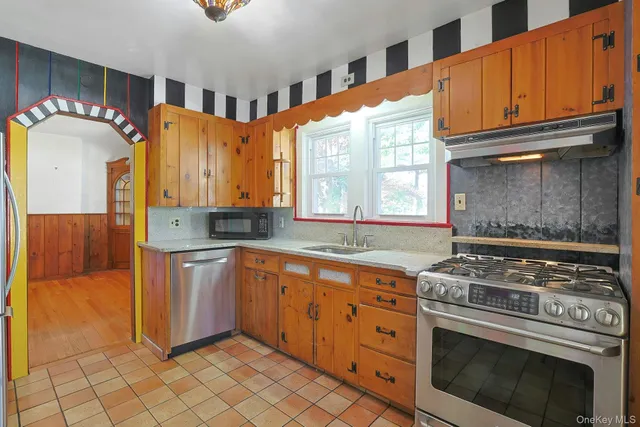 a kitchen with stainless steel appliances granite countertop a stove a sink and a microwave