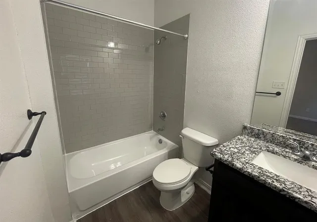 a bathroom with a granite countertop sink toilet and shower
