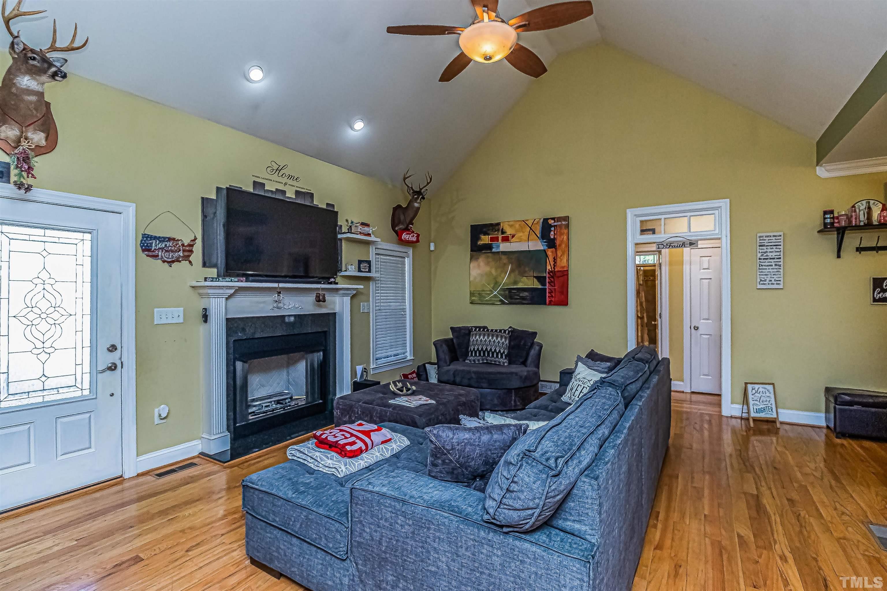 1197 Trotters Ridge Road Stem, NC 27581 - Photo 23 of 79 a living room with furniture a fireplace and a flat screen tv