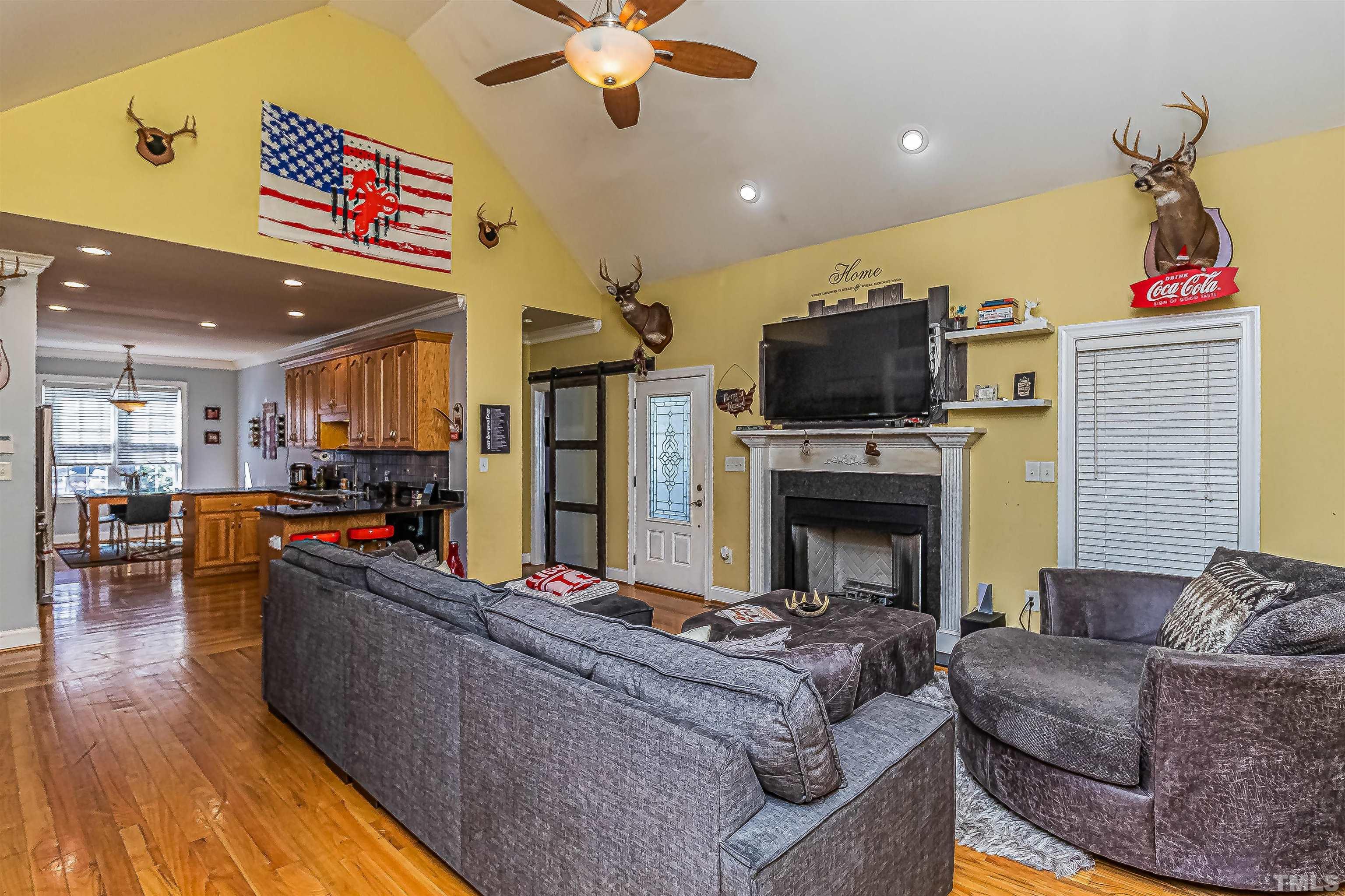1197 Trotters Ridge Road Stem, NC 27581 - Photo 24 of 79 a living room with furniture a flat screen tv and kitchen view