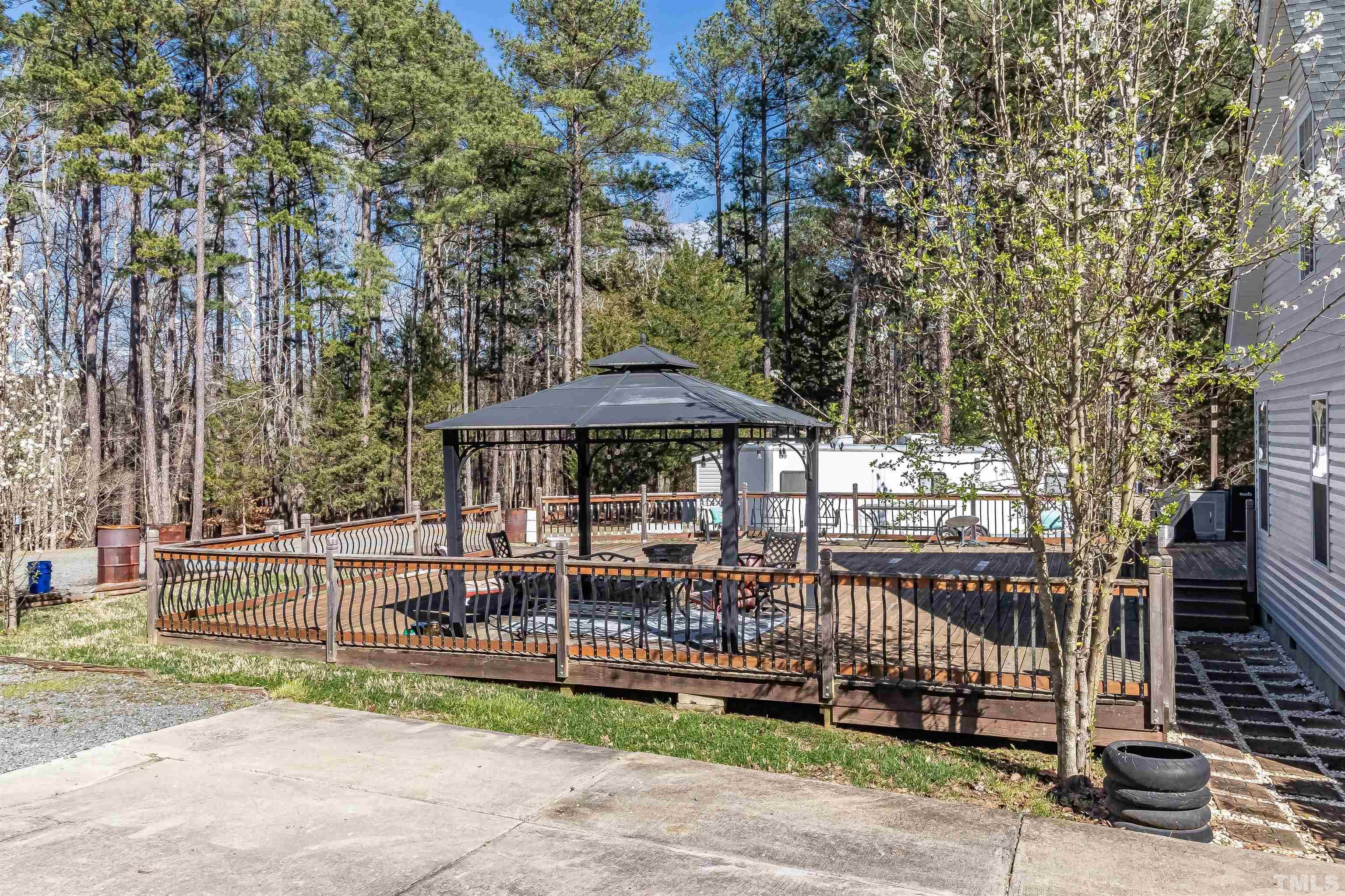 1197 Trotters Ridge Road Stem, NC 27581 - Photo 7 of 79 a view of a deck with a table and chair under an umbrella