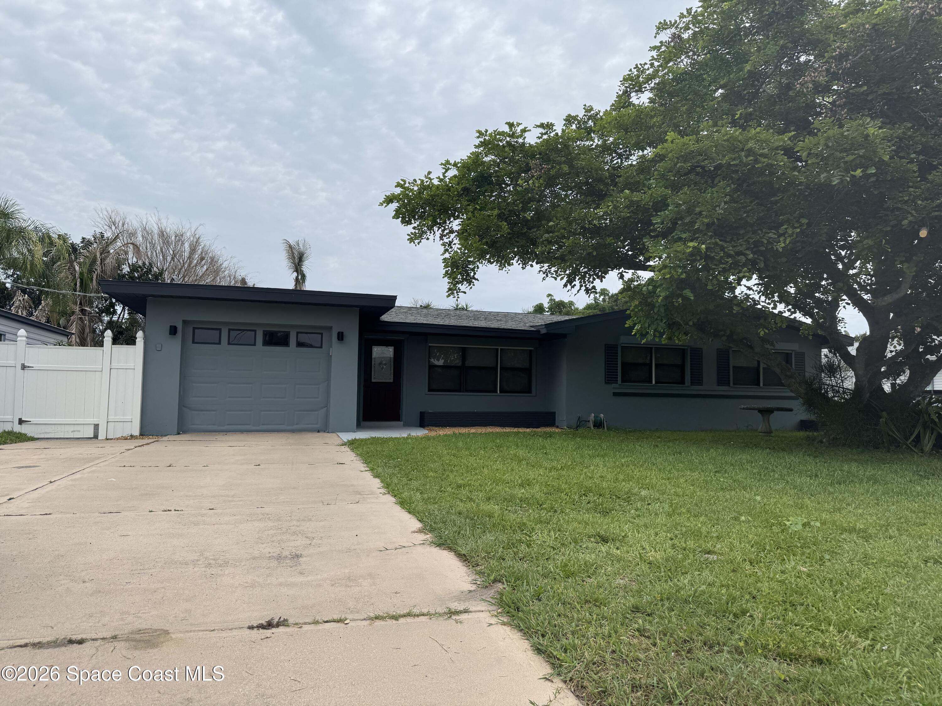 2135 South River Road Melbourne Beach, FL 32951 - Photo 1 of 1 a front view of a house with a garden and trees