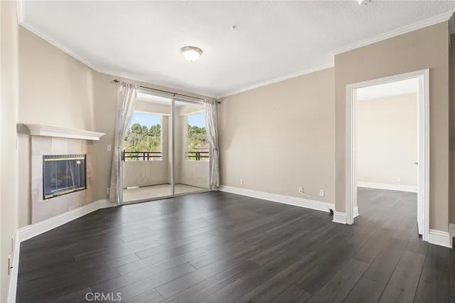 an empty room with wooden floor and a fireplace