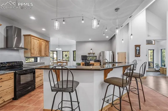 a kitchen with stainless steel appliances a table and chairs in it