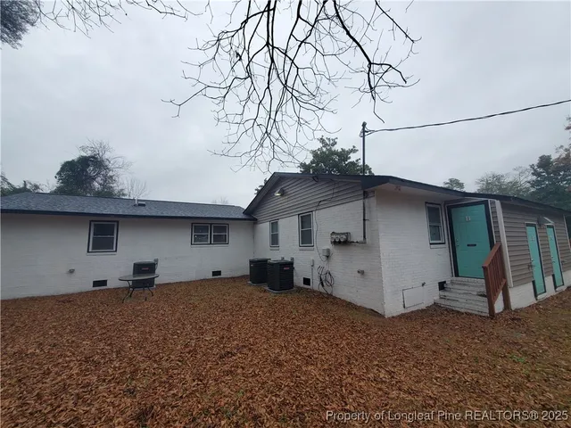 a front view of house with yard and trees in the background