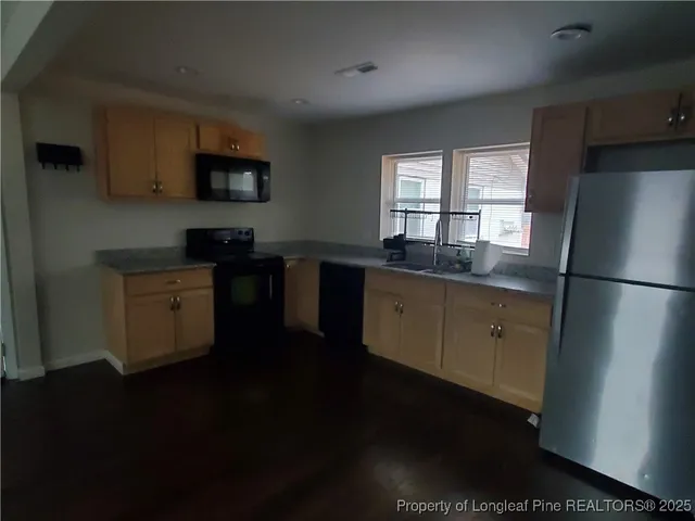 a kitchen with granite countertop a stove a sink and a microwave