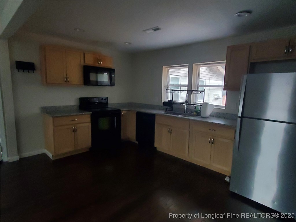 Undisclosed Address Fayetteville, NC 28305 - Photo 6 of 15 a kitchen with a sink a refrigerator and wooden cabinets