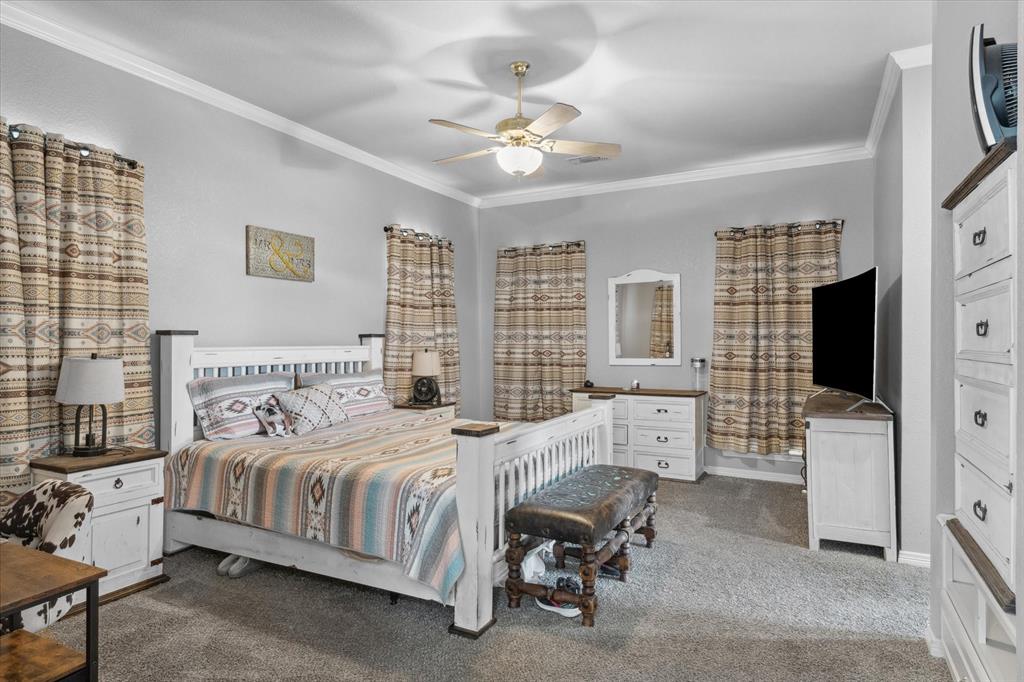 7182 Fm 2451 Road Scurry, TX 75158 - Photo 22 of 37 a bedroom with a bed a flat screen tv and chandelier