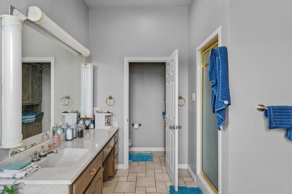 7182 Fm 2451 Road Scurry, TX 75158 - Photo 26 of 37 a bathroom with a granite countertop sink a mirror and a shower