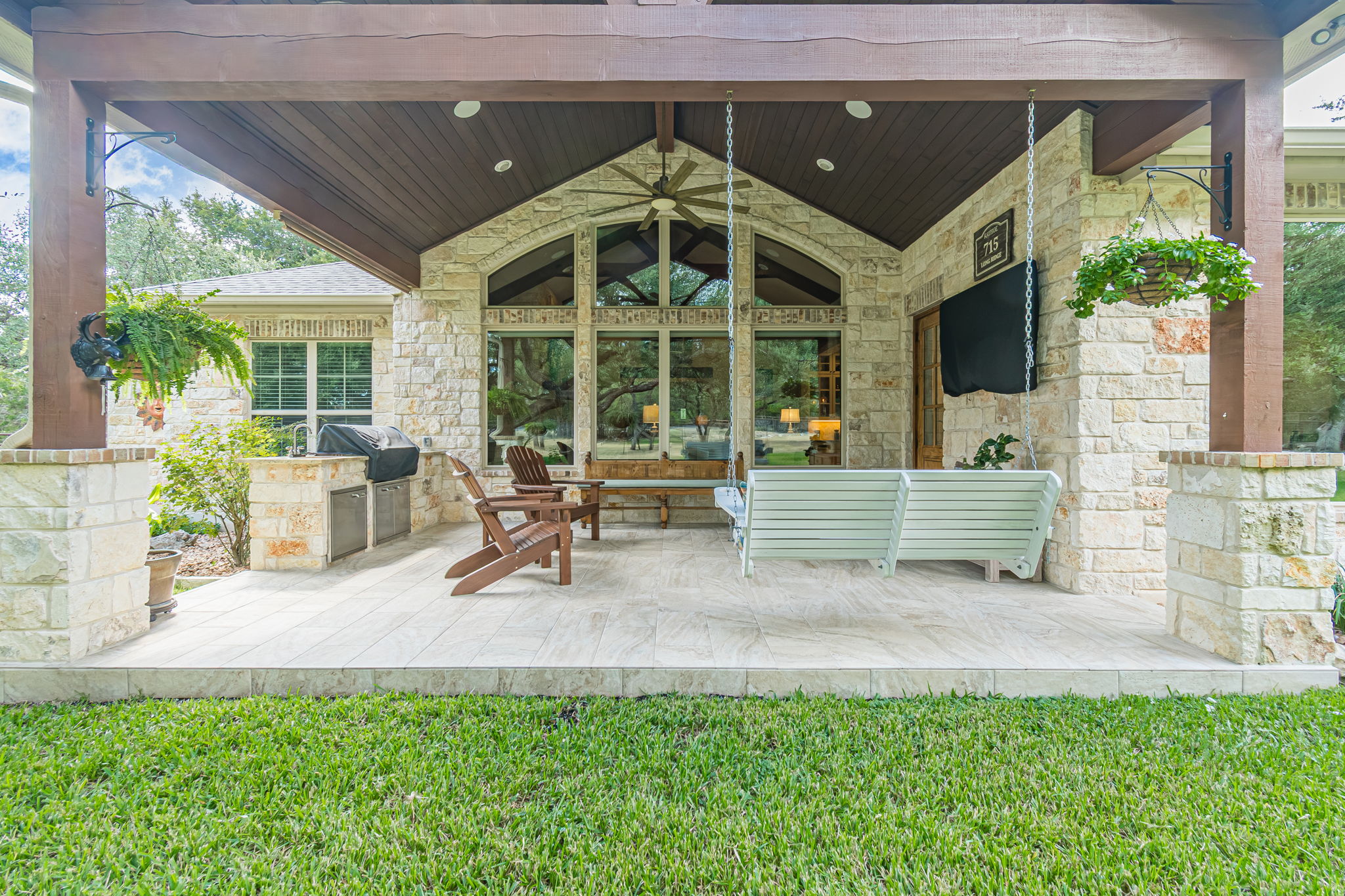 715 Long Ridge Spring Branch, TX 78070 - Photo 30 of 40 A spacious stone patio features wood-paneled vaulted ceilings and built-in outdoor kitchen elements.