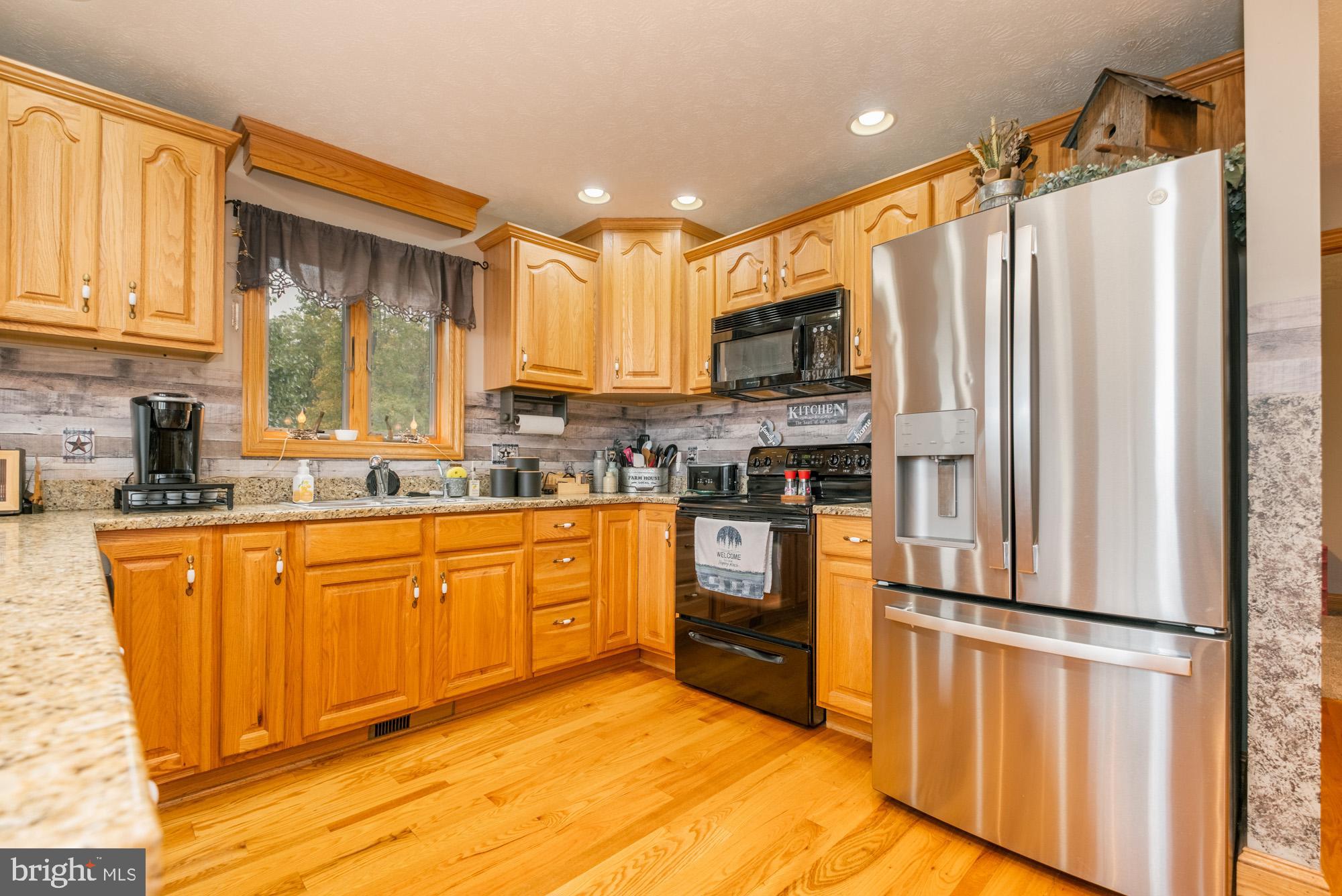 1875 Pysell Crosscut Road Oakland, MD 21550 - Photo 27 of 67 a kitchen with stainless steel appliances granite countertop a refrigerator a stove top oven a sink and dishwasher