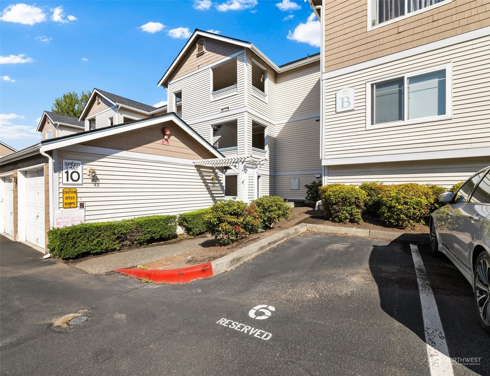 23908 Bothell Everett Highway, Unit B203 Bothell, WA 98021 - Photo 15 of 15 a view of a white house with a yard and plants
