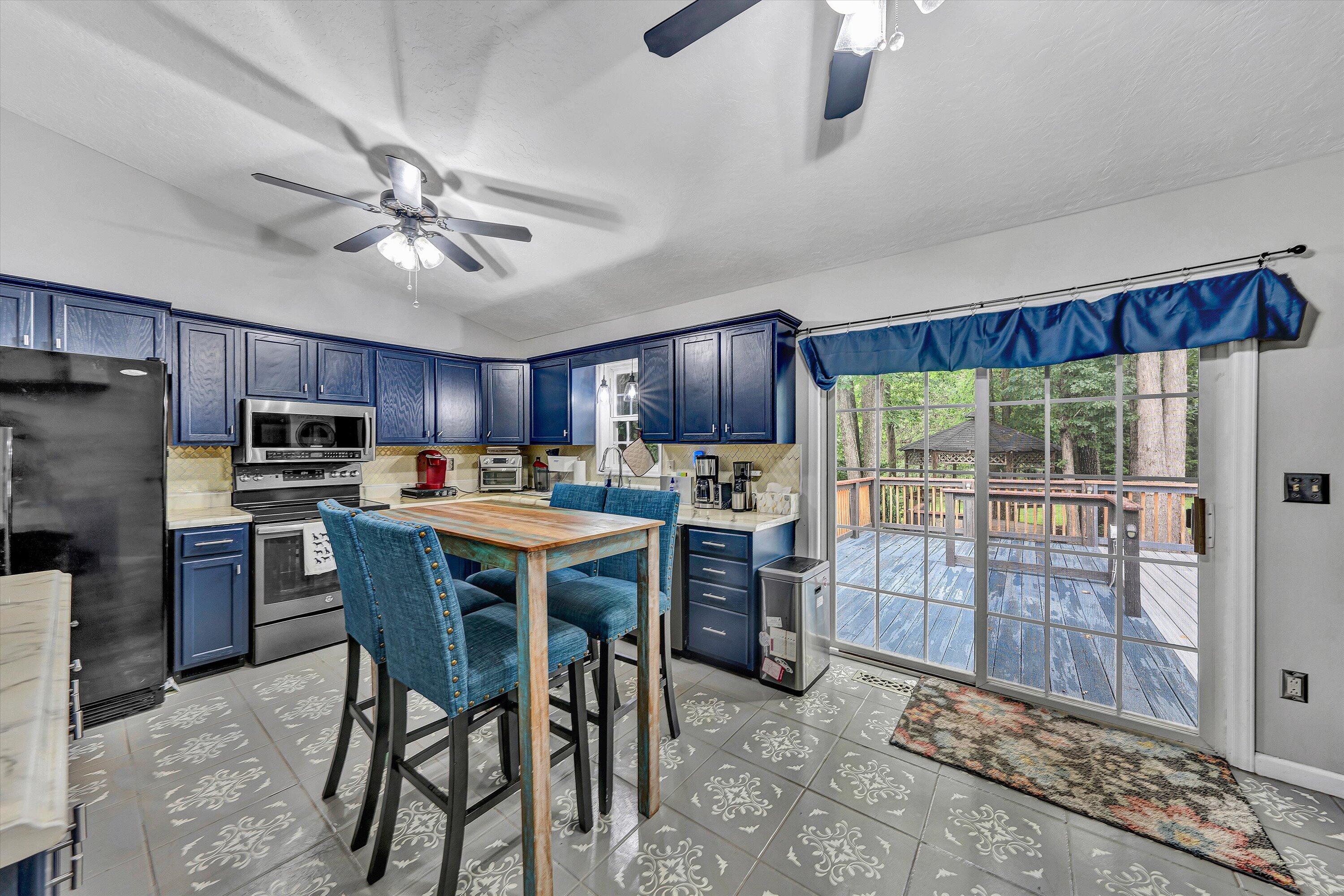5935 Scruggs Road Moneta, VA 24121 - Photo 9 of 37 a kitchen with stainless steel appliances kitchen island granite countertop a table chairs sink and cabinets