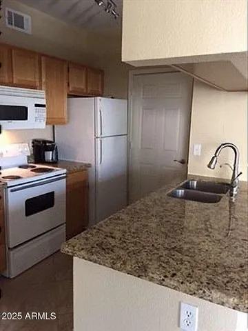 a kitchen with granite countertop a sink stainless steel appliances and cabinets